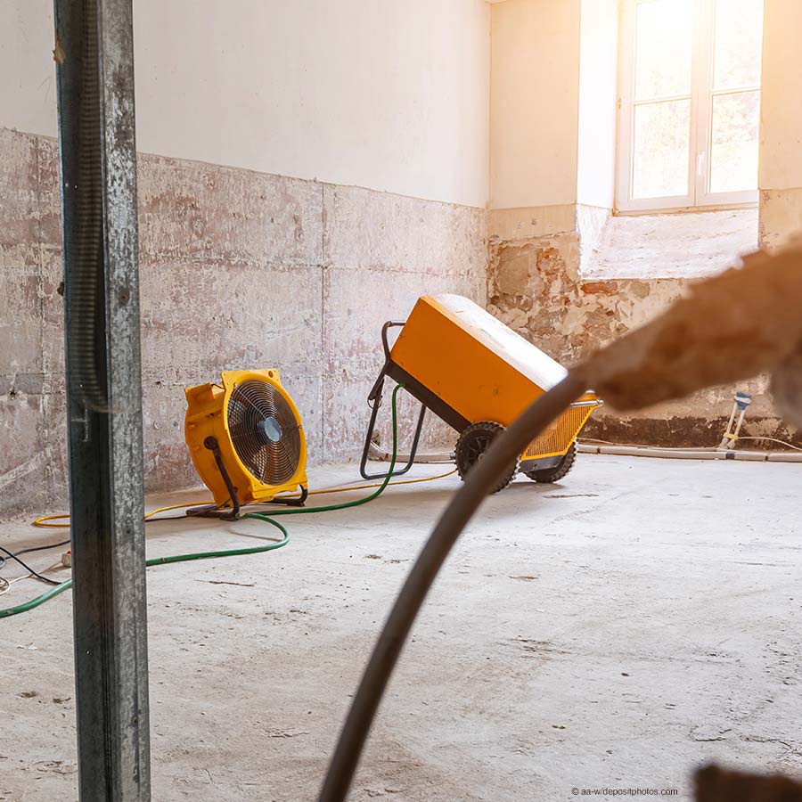 Bautrockner in einem Raum mit feuchten Wänden im Einsatz